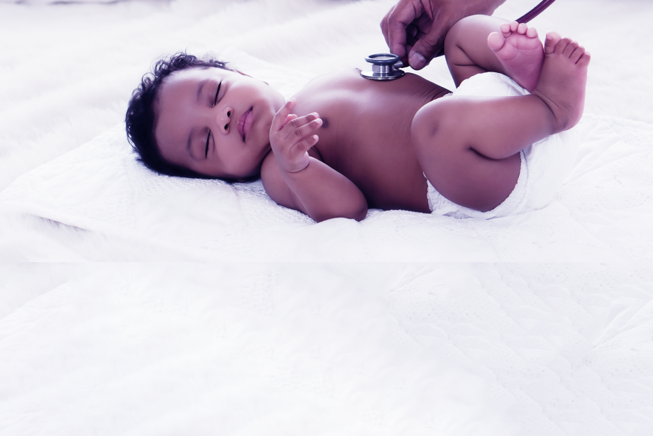 baby laying on white blanket with stethoscope on chest